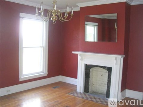 A room with red walls and a white fireplace.