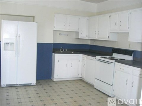 A kitchen with white appliances and cabinets.