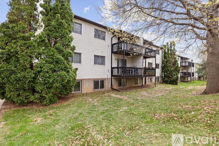 A tree is in front of a building with a balcony.