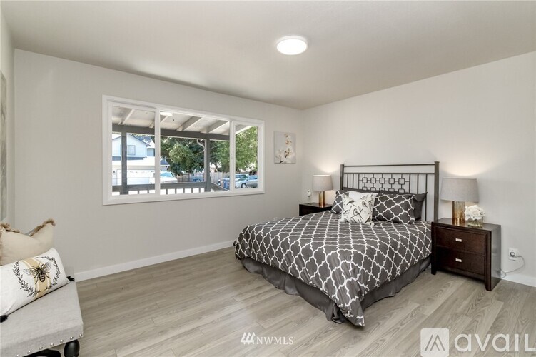 A bedroom with a large bed and a window overlooking a street.
