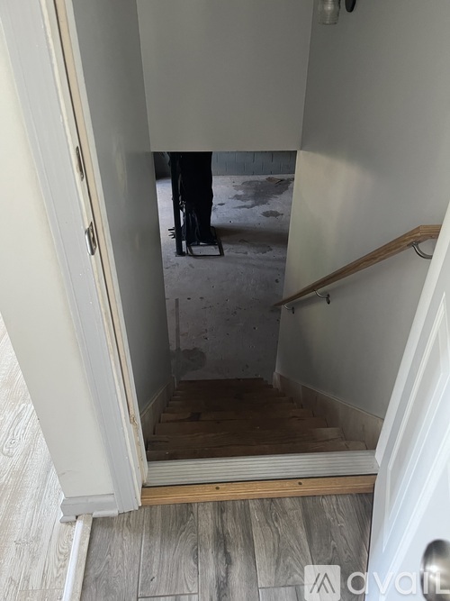 A person is standing in a doorway with a white door.