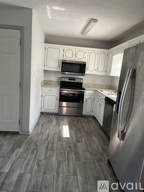 A kitchen with a refrigerator, oven, and microwave.