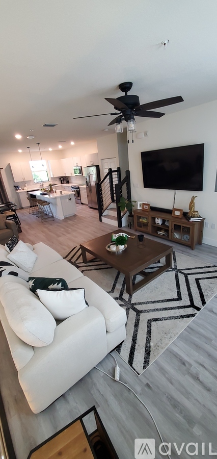 A living room with a white couch and a ceiling fan.