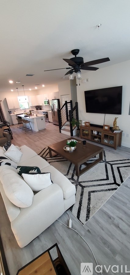 A living room with a white couch and a ceiling fan.