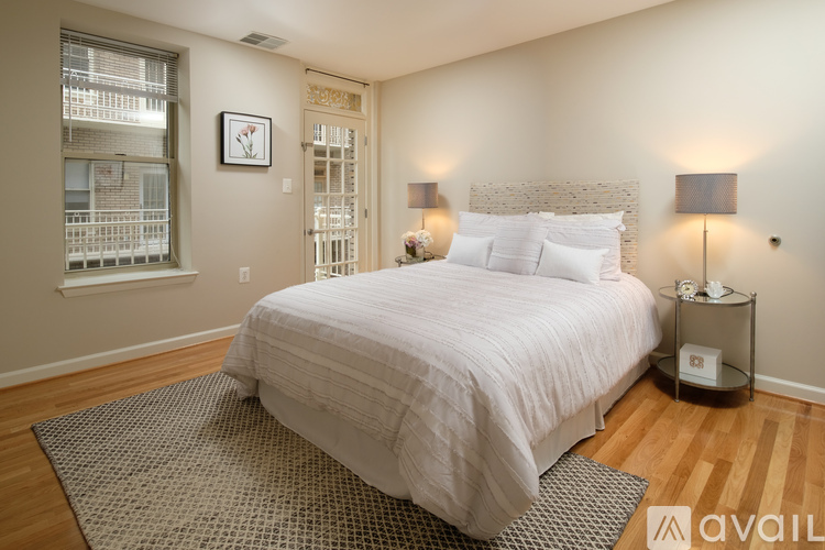 A bedroom with a large bed and a window with blinds.
