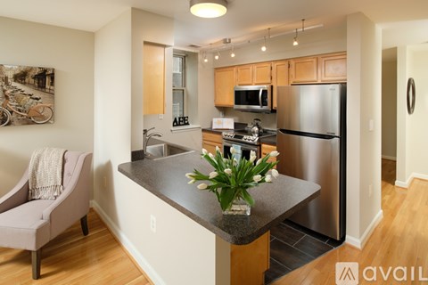 A kitchen with a refrigerator, sink, and countertop.