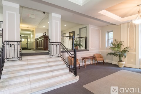 A spacious interior with a staircase, a bench, and a potted plant.