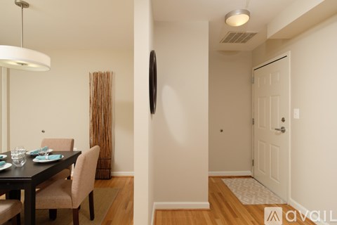 A dining room with a table set for two and a white door.