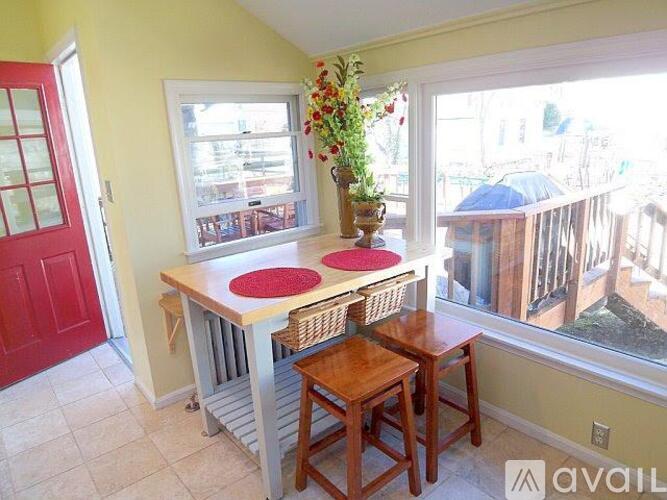 A small table with two chairs and a vase of flowers on it.