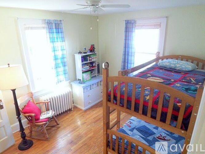 A bedroom with a bed, chair, and window.
