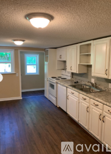 A kitchen with white cabinets and a granite counter top.