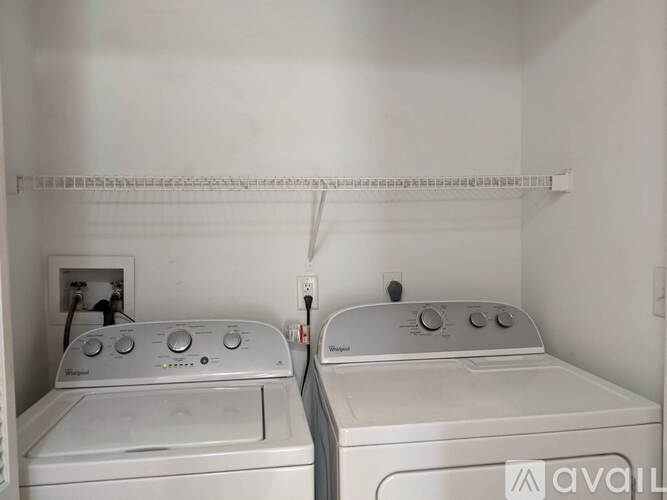 Two front loading washing machines in a small laundry room.
