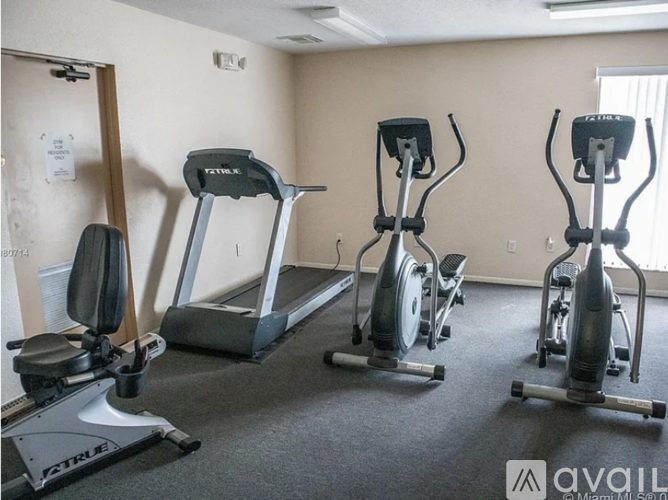 A gym with treadmills, elliptical machines, and stationary bikes.
