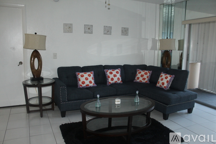 A living room with a black couch and a round table.