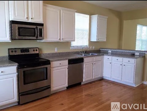 A kitchen with white cabinets and a black stove top.