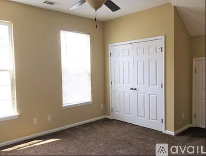 A room with a white door and a window on the left side.