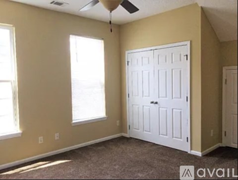 A room with a white door and a window on the left side.