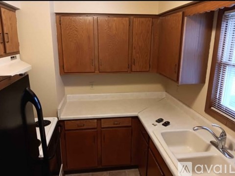 A kitchen with wooden cabinets and a white sink.