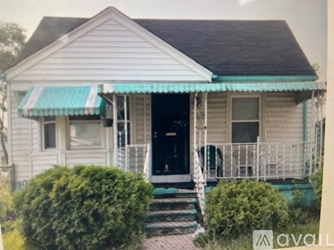 A house with a blue awning and a black door.
