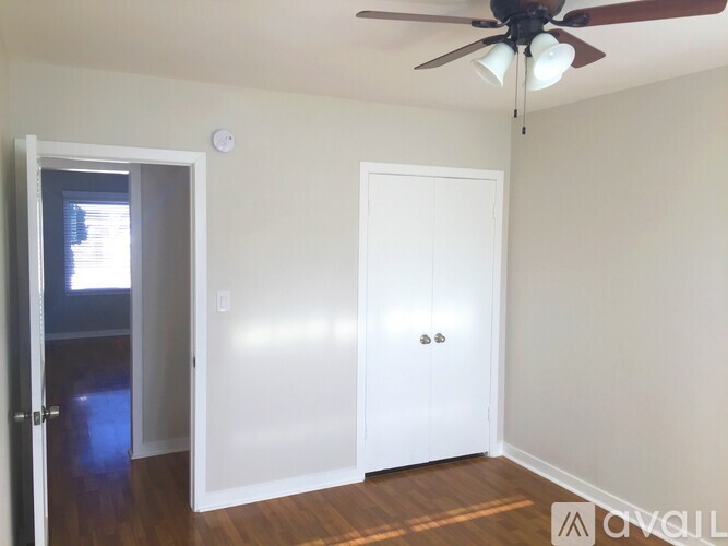 A room with a ceiling fan and two doors.