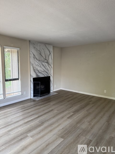A living room with a fireplace and wood flooring.