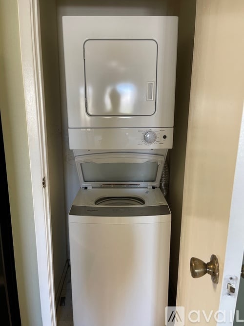 A white dishwasher is in a small space next to a door.