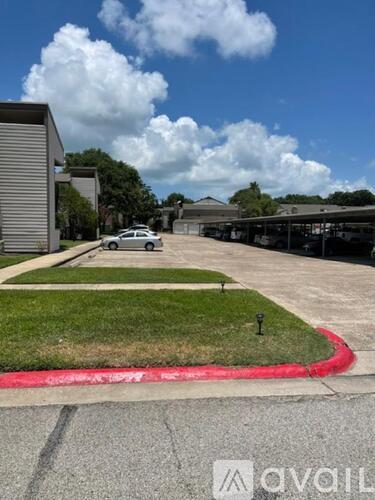 A car is parked in a parking lot with a building in the background.