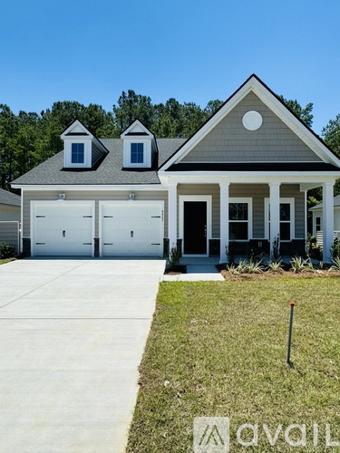 A house with a grey roof and white garage doors.