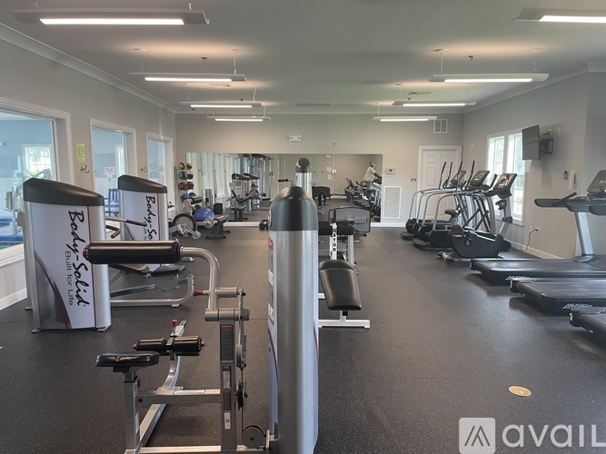 A gym with a variety of equipment including treadmills, stationary bikes, and weight machines.