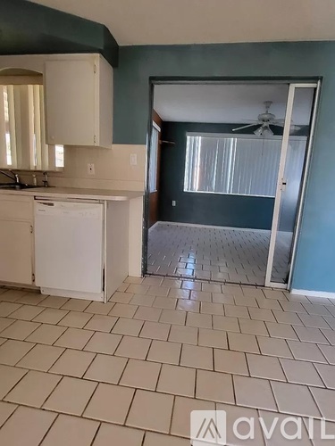 A kitchen with a white dishwasher and a fan.