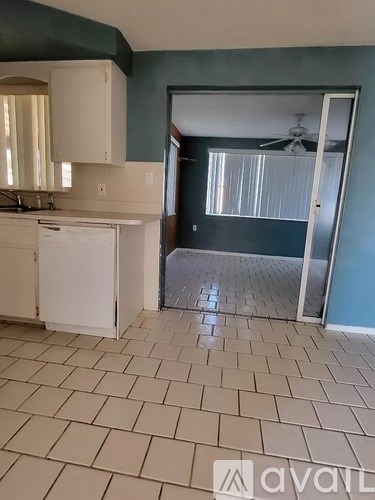 A kitchen with a white dishwasher and a fan.