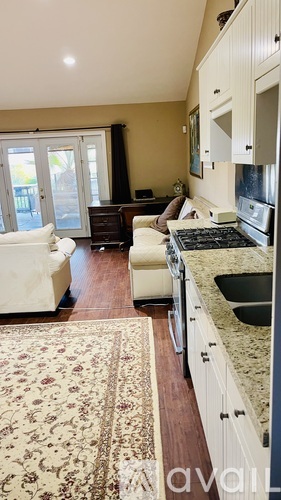 A kitchen with a rug on the floor and a sink with a faucet.