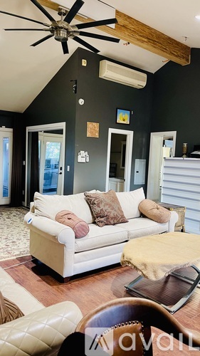 A living room with a white couch and a ceiling fan.