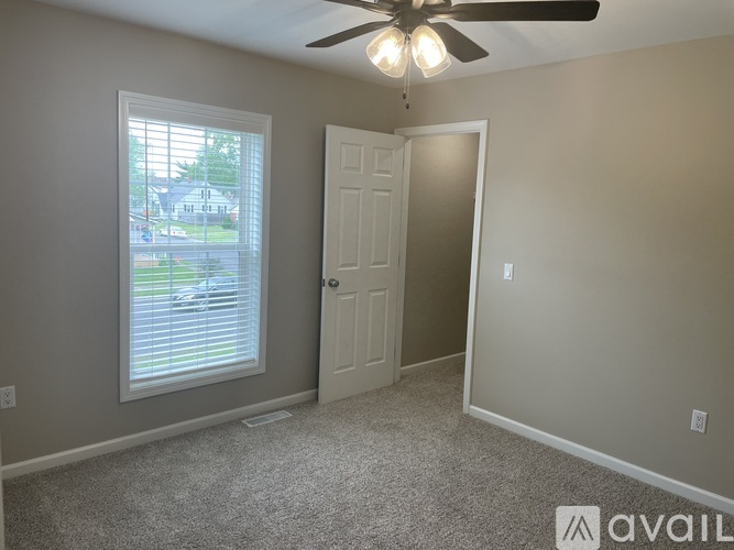 A room with a ceiling fan and a door.