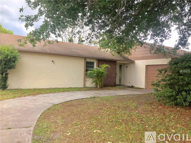 A house with a brown roof and a beige wall with a garage door.