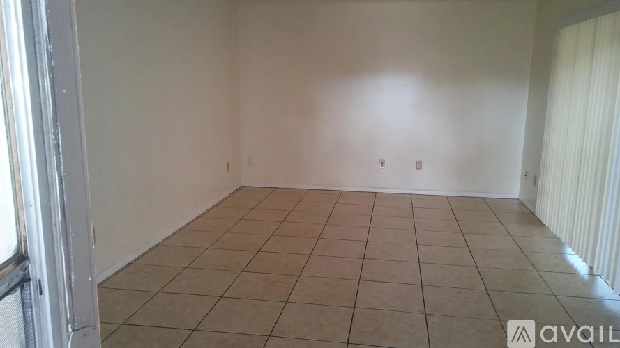 A room with beige tiled flooring and white walls.