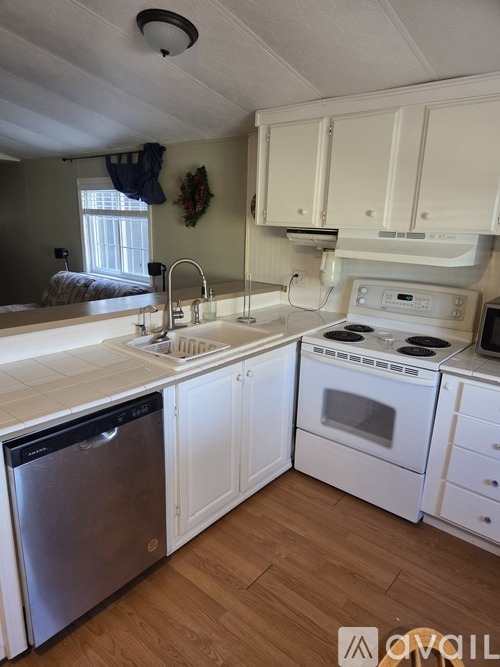 A kitchen with white cabinets and a stainless steel dishwasher.