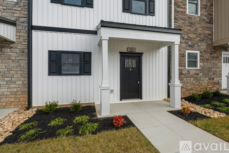 A modern house with a black front door and a white front porch.