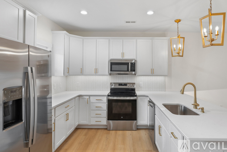 A modern kitchen with white cabinets and stainless steel appliances.
