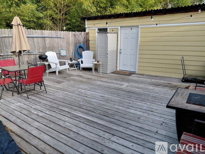 A wooden deck with chairs and an umbrella.