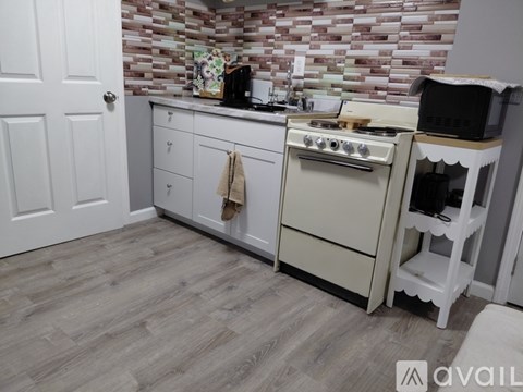 A kitchen with a white oven and a white door.