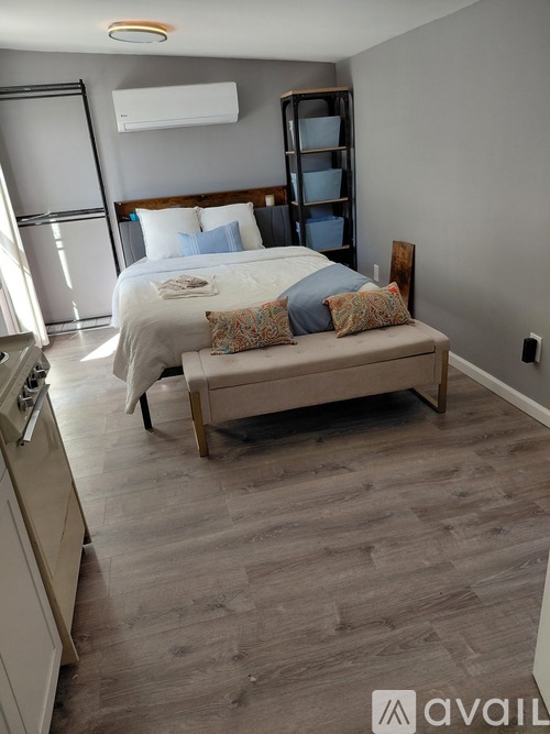 A bedroom with a bed, pillows, and a bench.