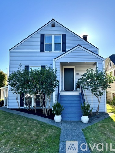 A house with a blue front yard and a white fence.