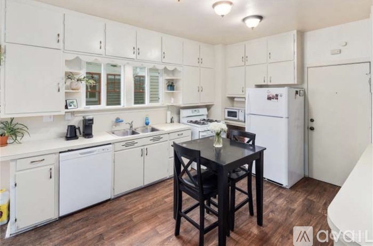 A kitchen with white cabinets and a black table.