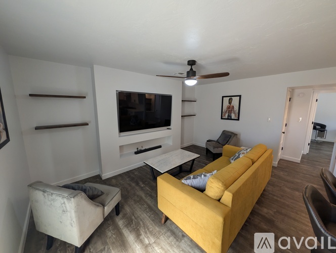 A living room with a yellow couch and a flat screen TV.