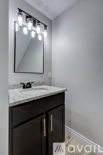 A bathroom vanity with a mirror and lights above it.