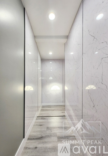 A long hallway with marble floors and walls.