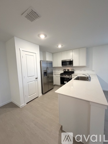 A kitchen with white cabinets and a white island.