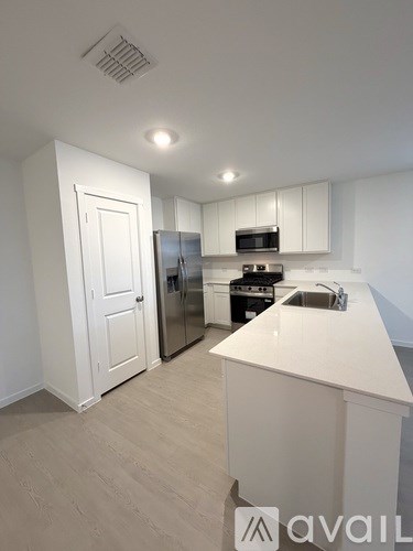 A kitchen with white cabinets and a white island.