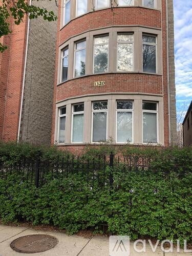 A tall red brick building with the number 320 on the side.